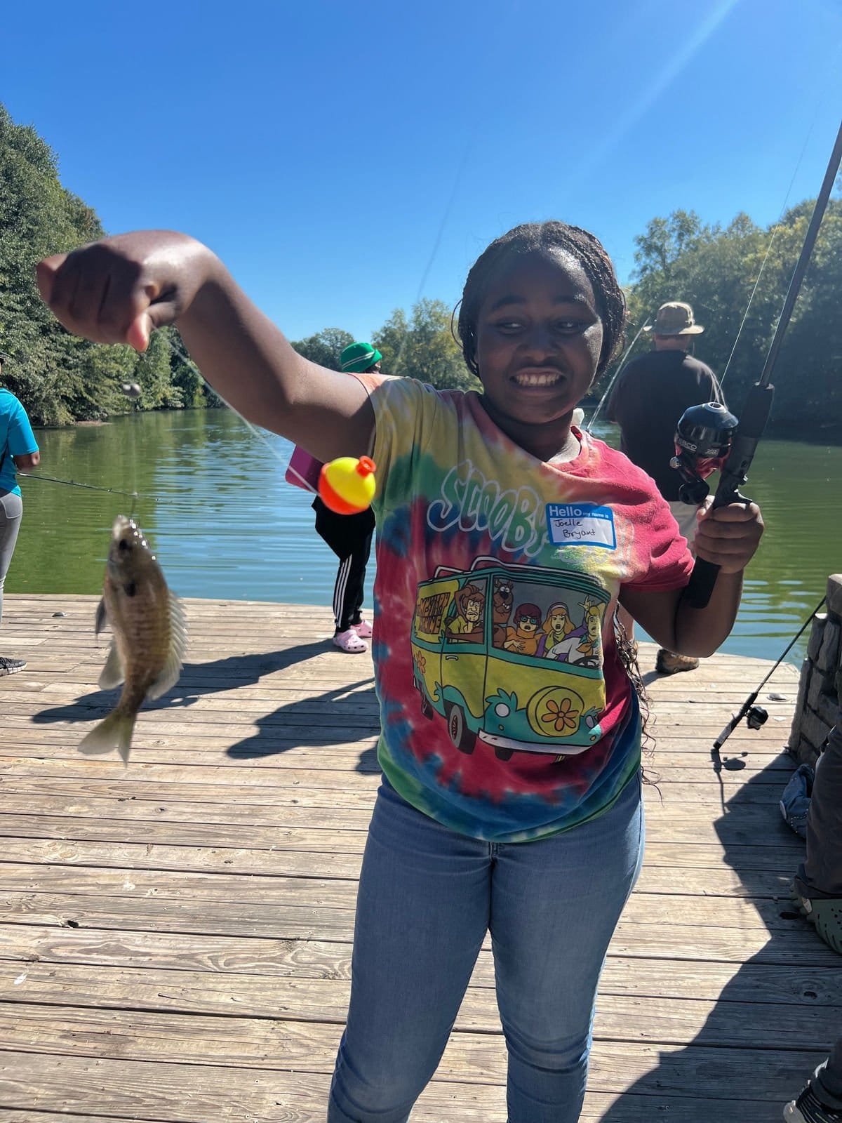 A young angler holds up her first fish